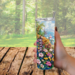 Woman holding floral beach tumbler outdoors at sunny table